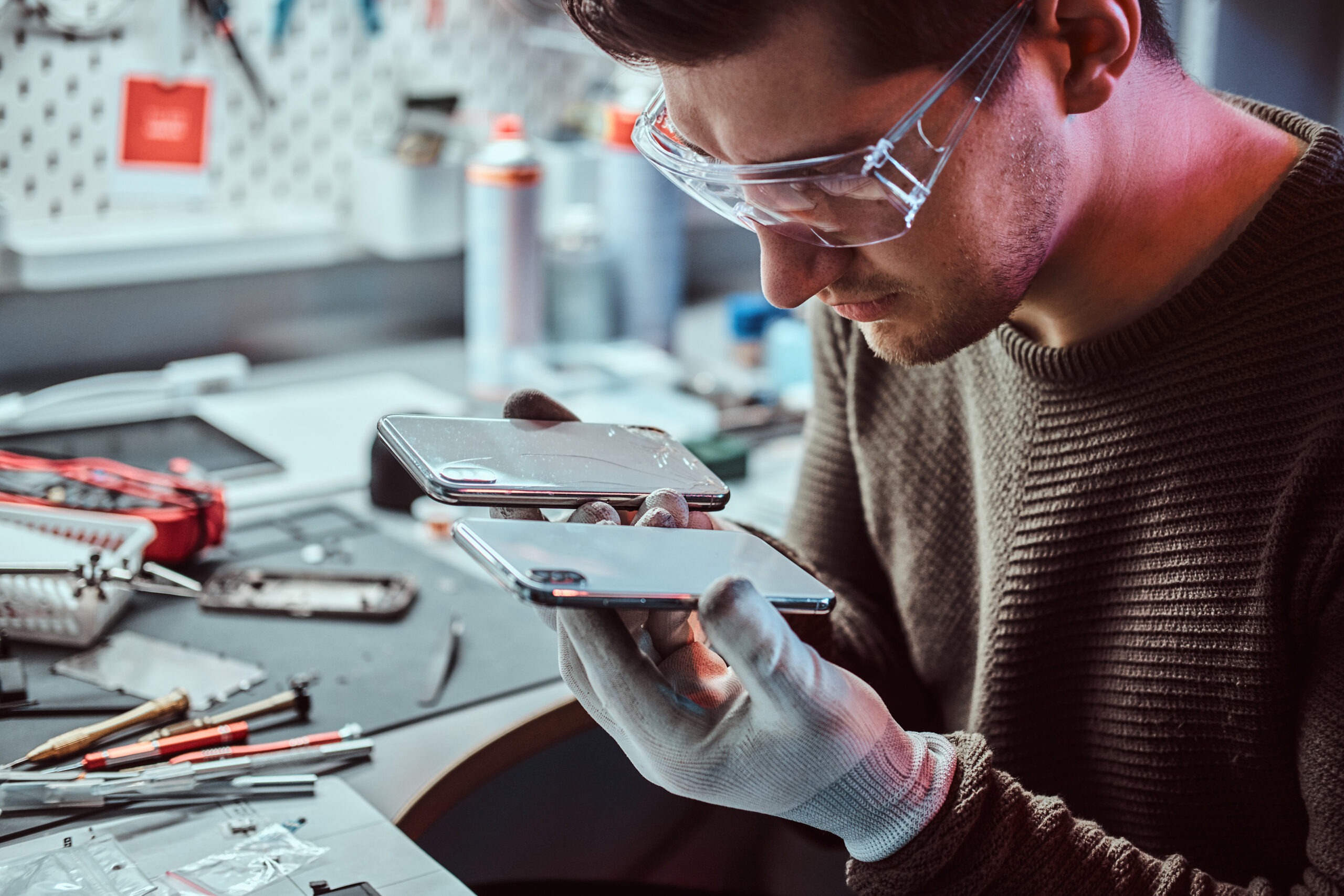 Electronic technician holds two identical smartphones